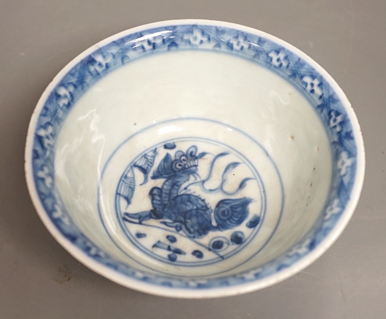A Chinese late Ming blue and white lion-dog bowl, the base with ‘Made in the Great Ming dynasty’ mark, white exterior, 13cm diameter